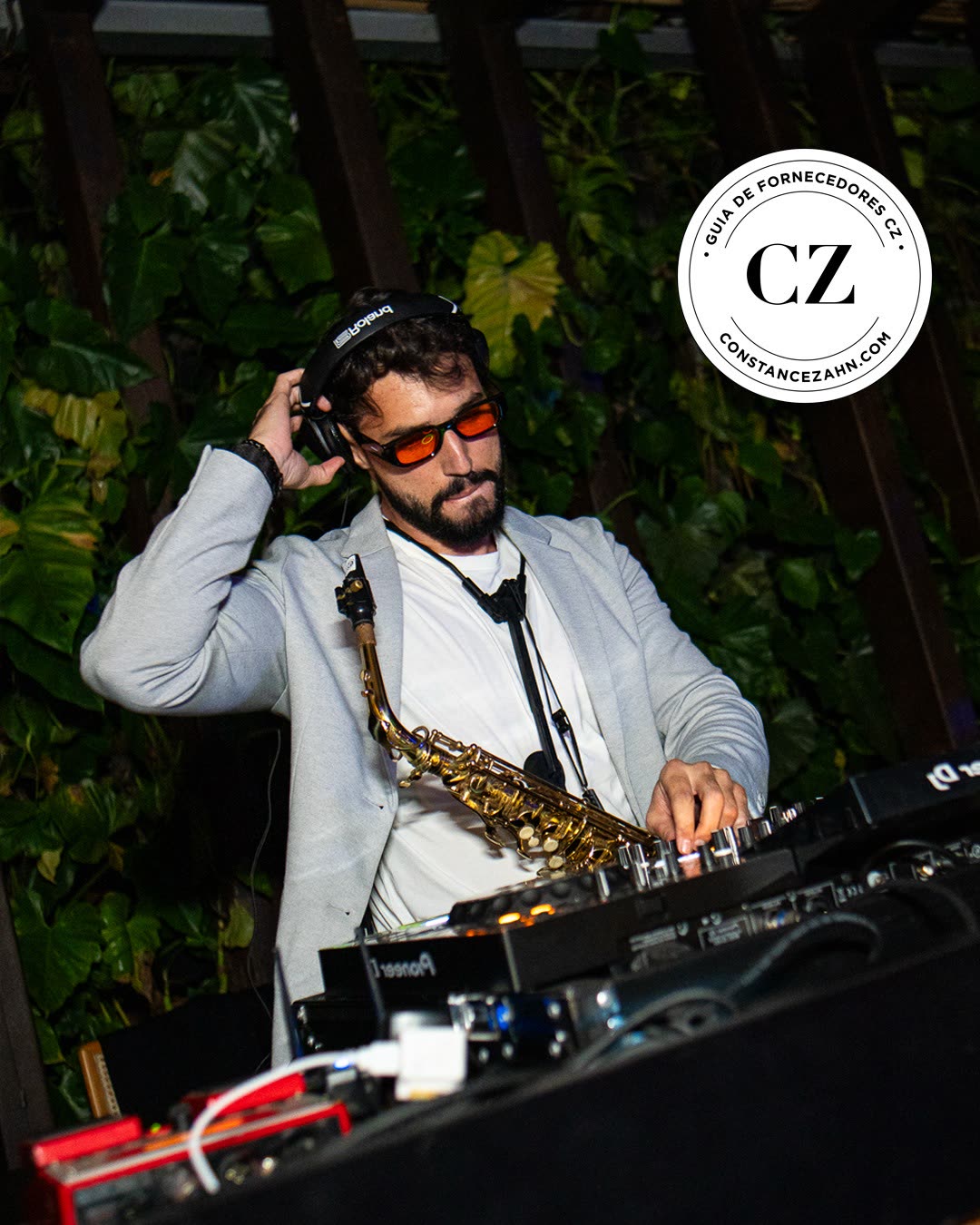 Bruno Daner no set de DJ com o saxofone, com o selo Guia de Fornecedores CZ da Constance Zahn